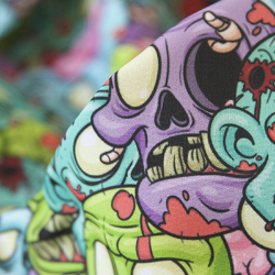 Pastel green, purple and blue zombie heads repeat throughout this design, some with their mouths open and ready for braaaaainnss. 
