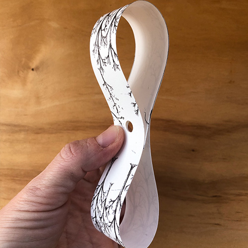 DIY gift bow step 2: Punch a hole in the center of the paper strips | Spoonflower Blog 