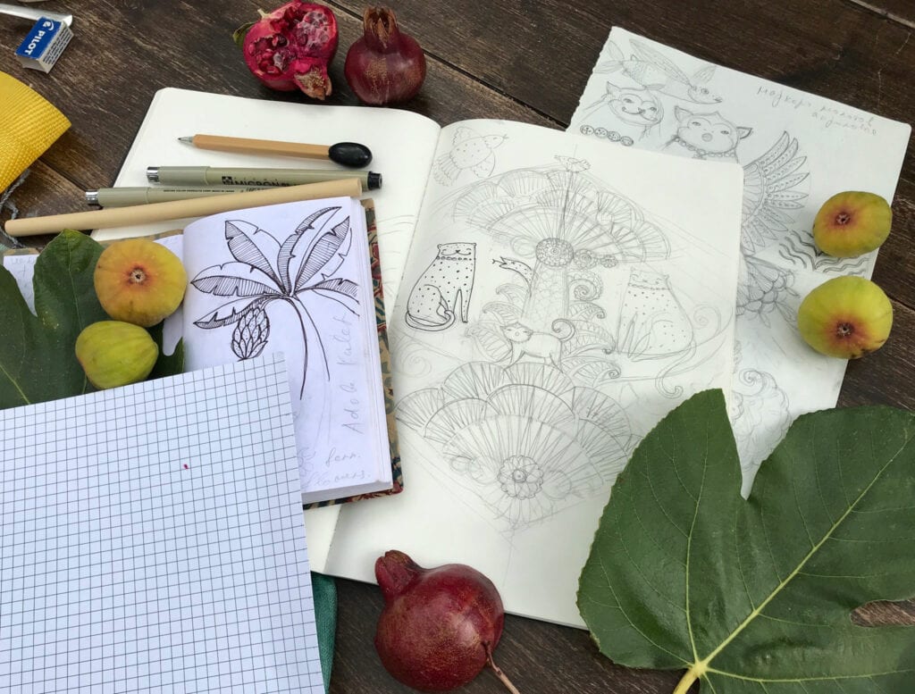 Elmira's sketchbook sits on a table with her inspiration