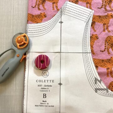 A sewing pattern on top of fabric featuring a cheetah pattern