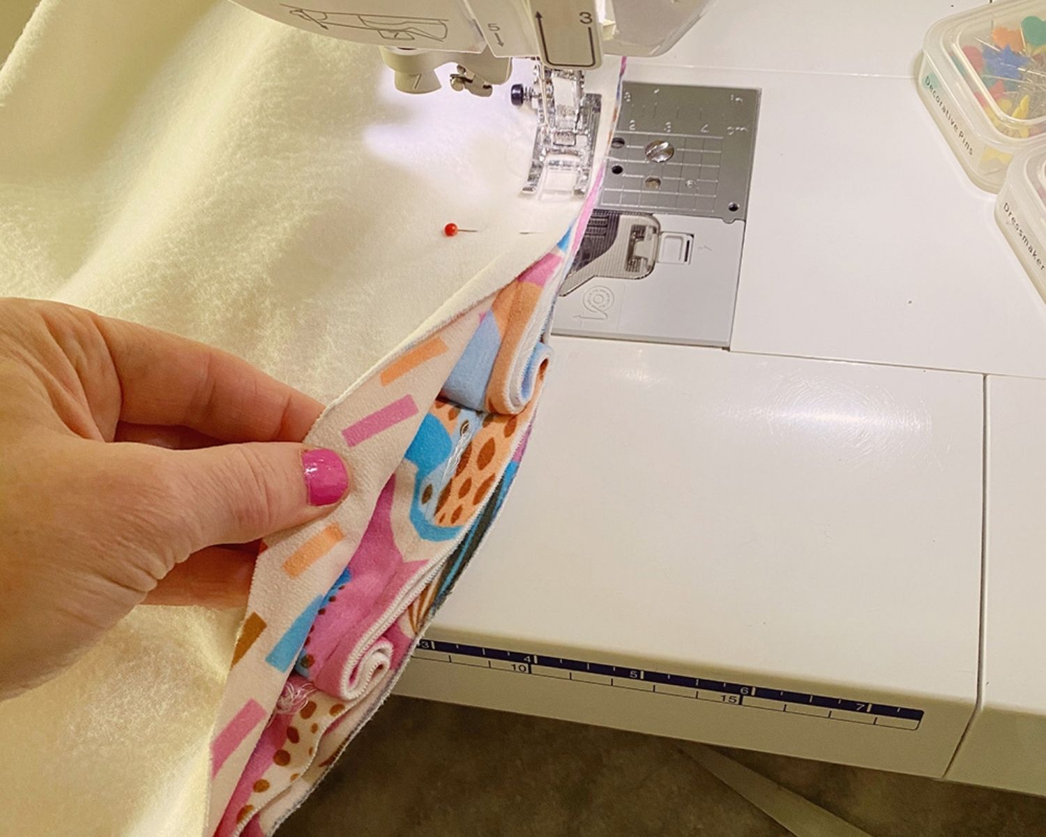 Using a sewing machine to sewing the final circle on top of the ruffled edge and base circle
