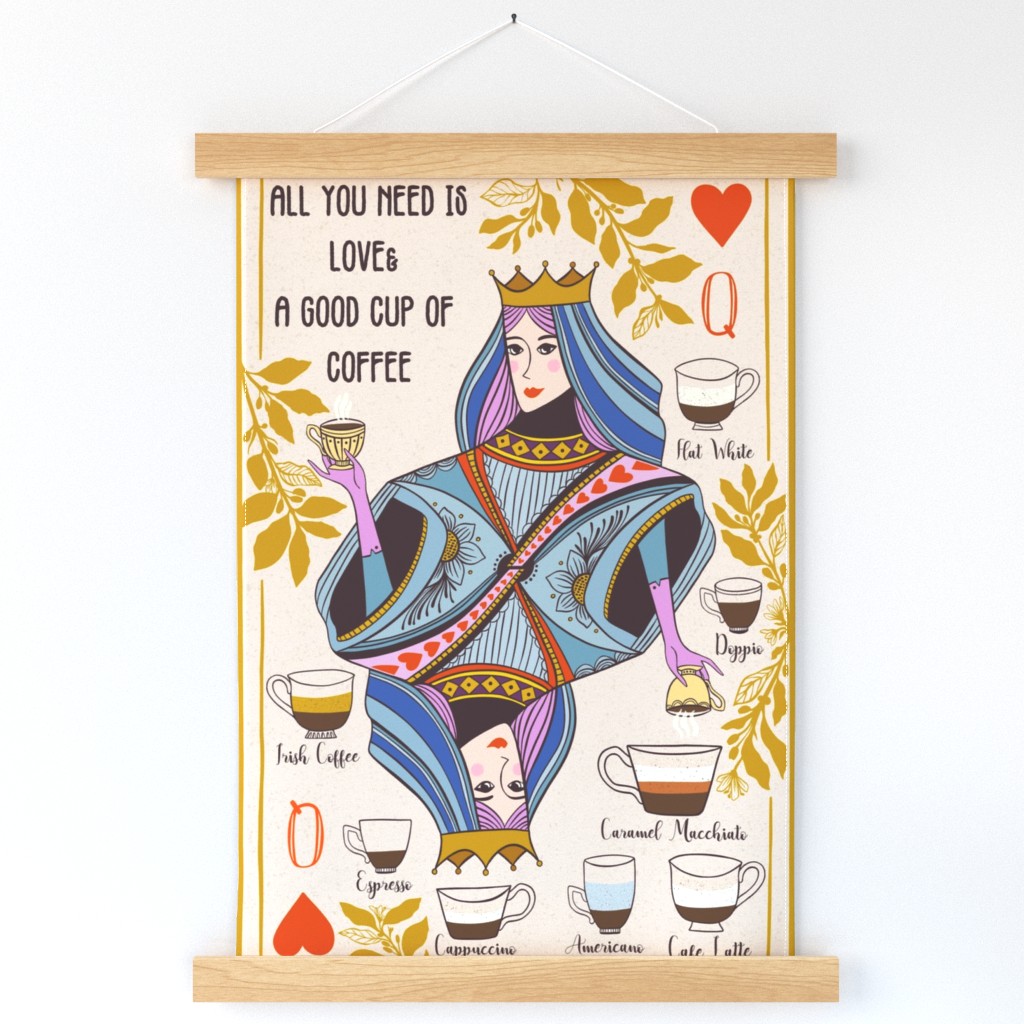 A wall hanging of a hand-drawn Queen of Hearts playing card, featuring a queen wearing shades of blue and a gold crown, that says "All you need is love and a good cup of coffee" in black font hangs on a white wall