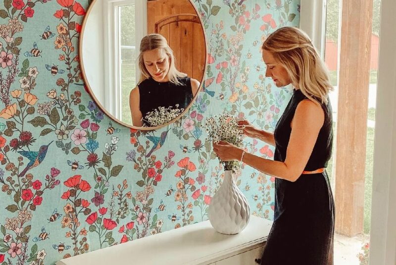 Floral wallpaper in an entryway with a mirror
