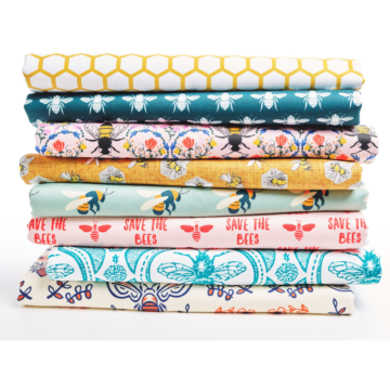 A stack of fabric designs relate to bees, from a large golden honeycomb design to mod and ant deco bees to a plea to save the bees.