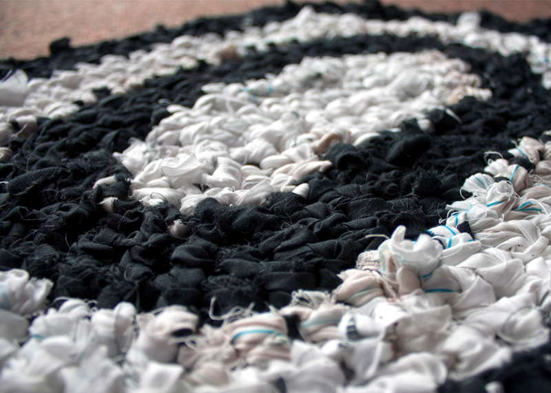 A close up of a white and black crochet rag rug. 