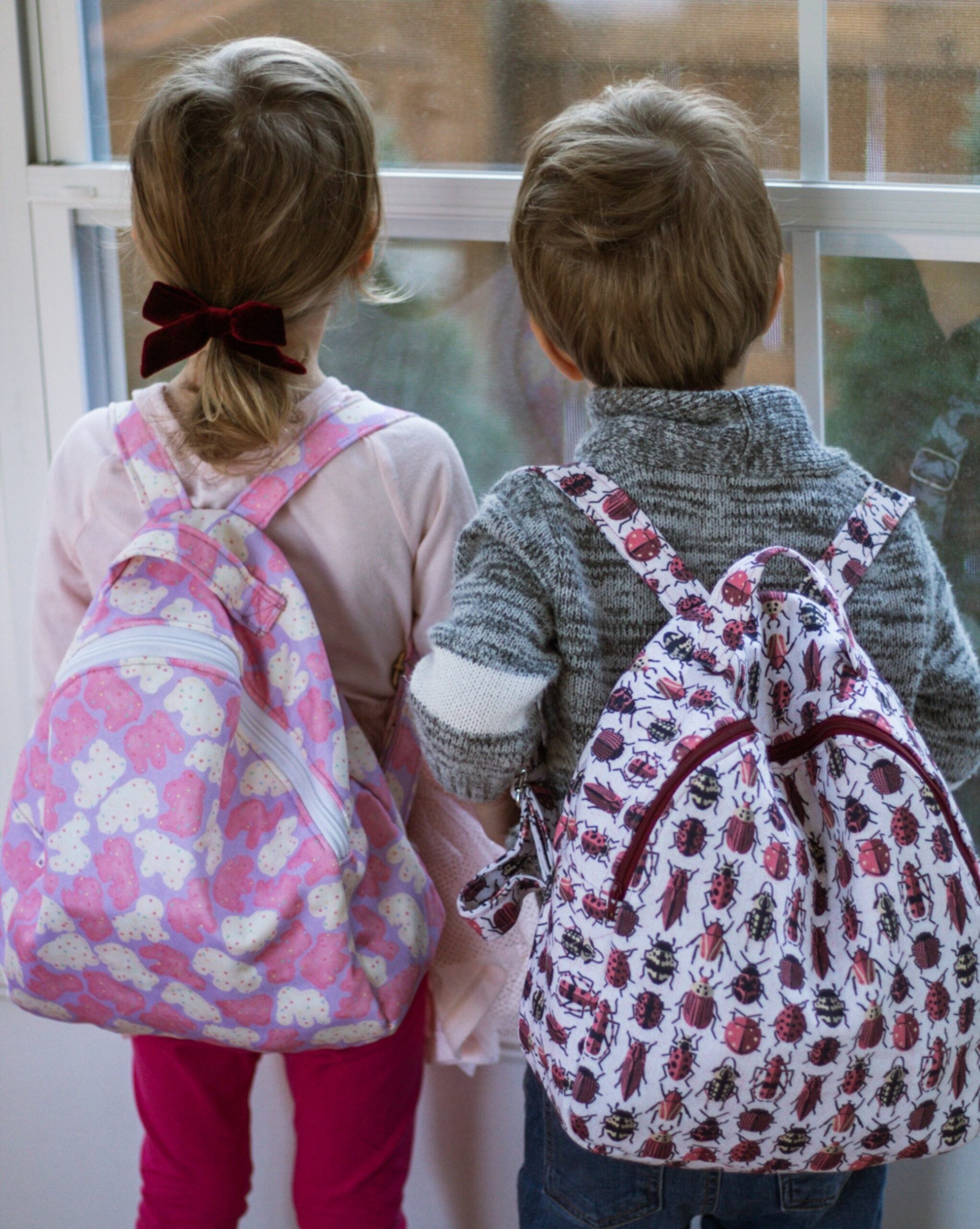 Two toddlers wearing mini backpacks