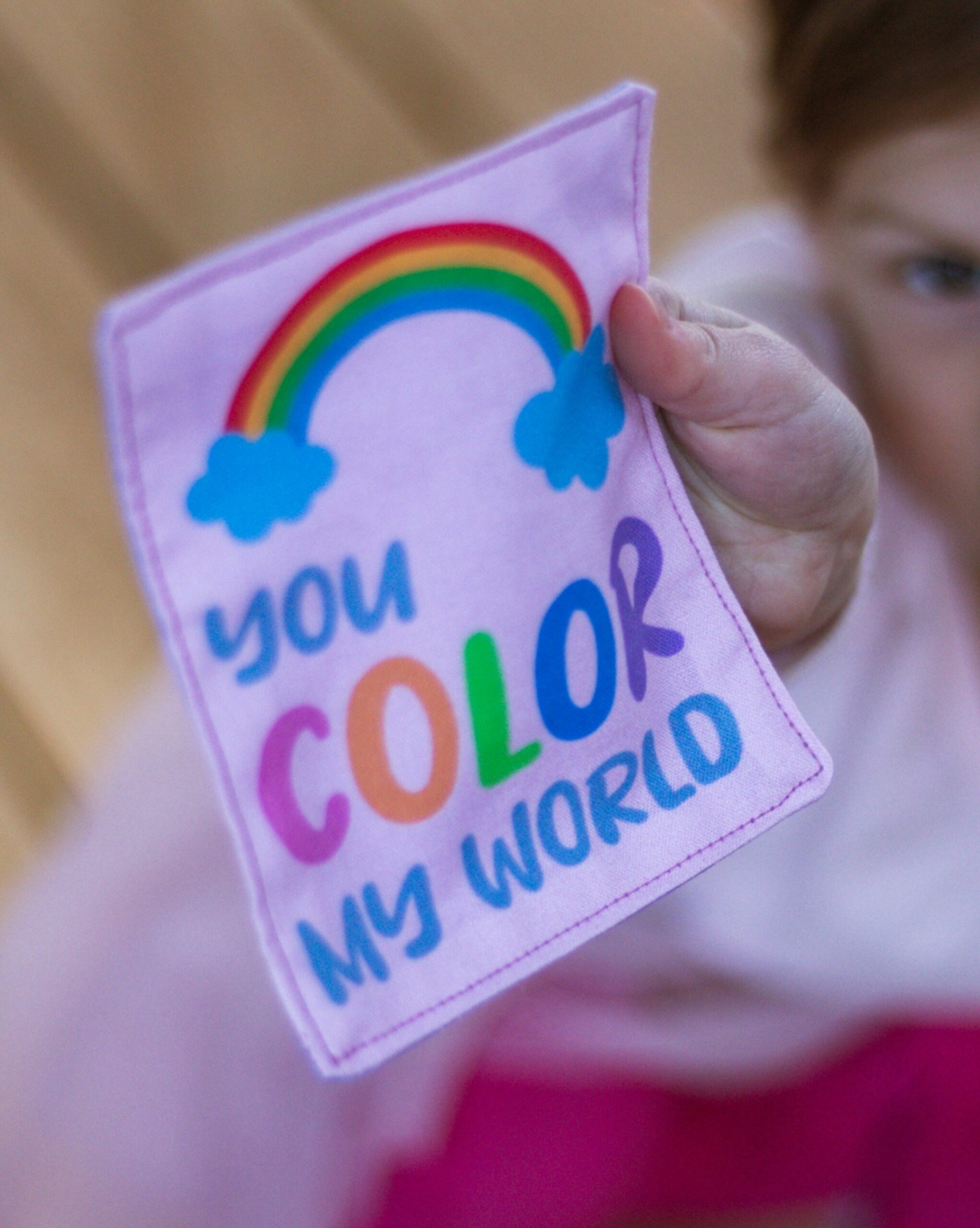 the "You color my world" love note held up close by a toddler