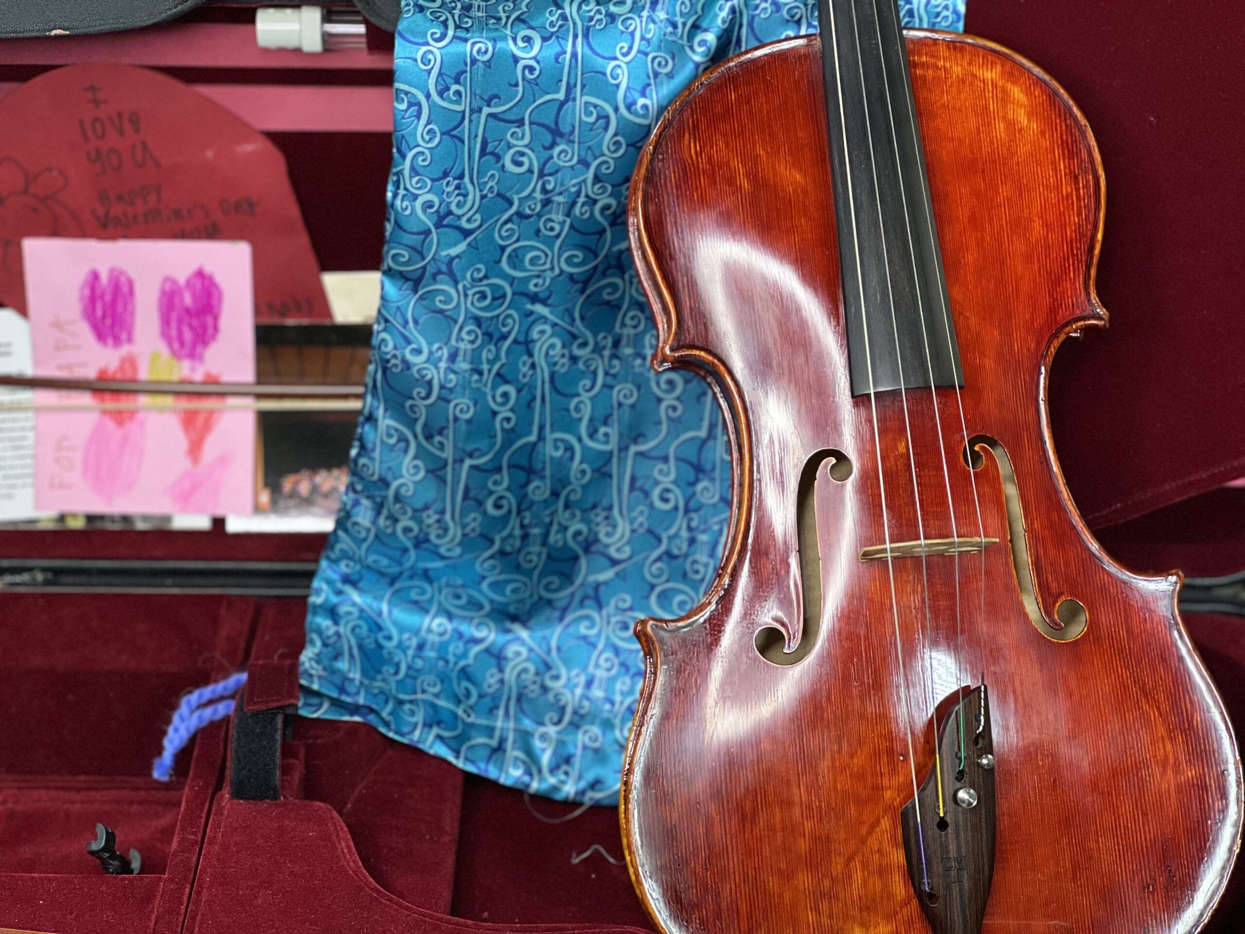 A cherry wood red viola and a blue drawstring storage bag