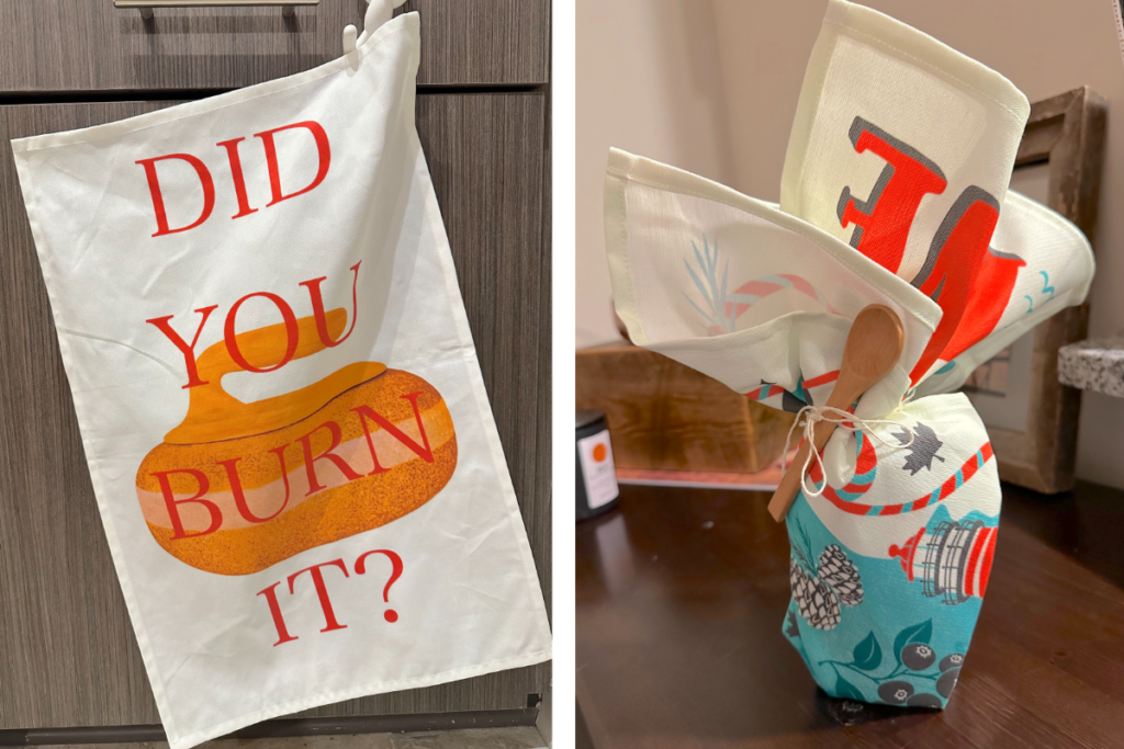 Two images have been placed side by side. At left, a tea towel with a white background and red text in all caps that says DID YOU BURN IT with an orange curling stone behind it. The tea towel is hanging from a small white plastic hanger in front of wooden cabinets. At right, a tea towel with a vintage Maine design has been used to wrap a gift that is sitting on a wooden table. A small wooden spoon is tied around the top of the gift with white twine.