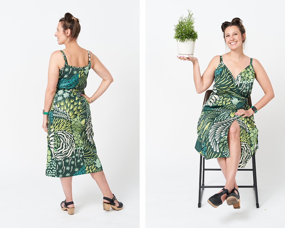 Two photos have been placed side by side in a rectangle. On the left, Theresa stands with her back to the camera to show off the back of her wrap dress. On the right, Theresa sits on a wooden stool and holds up a green plant in a white container with her right hand. In both images she is standing in front of a white background. The design on the dress features a dark green background and lots of varying moss designs with a few frogs jumping in and around the moss.