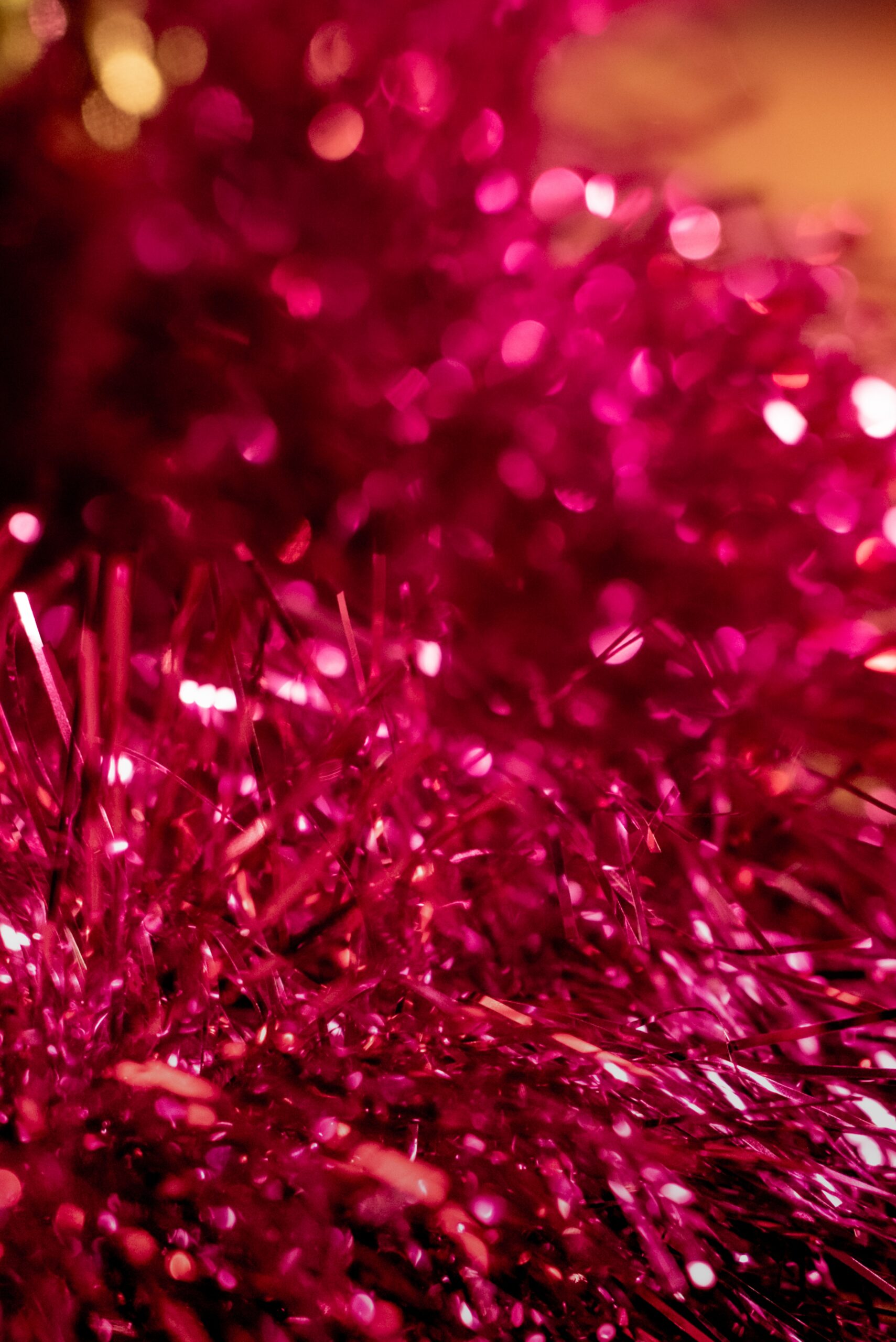 A close up of bright pink garland on a wooden table.
