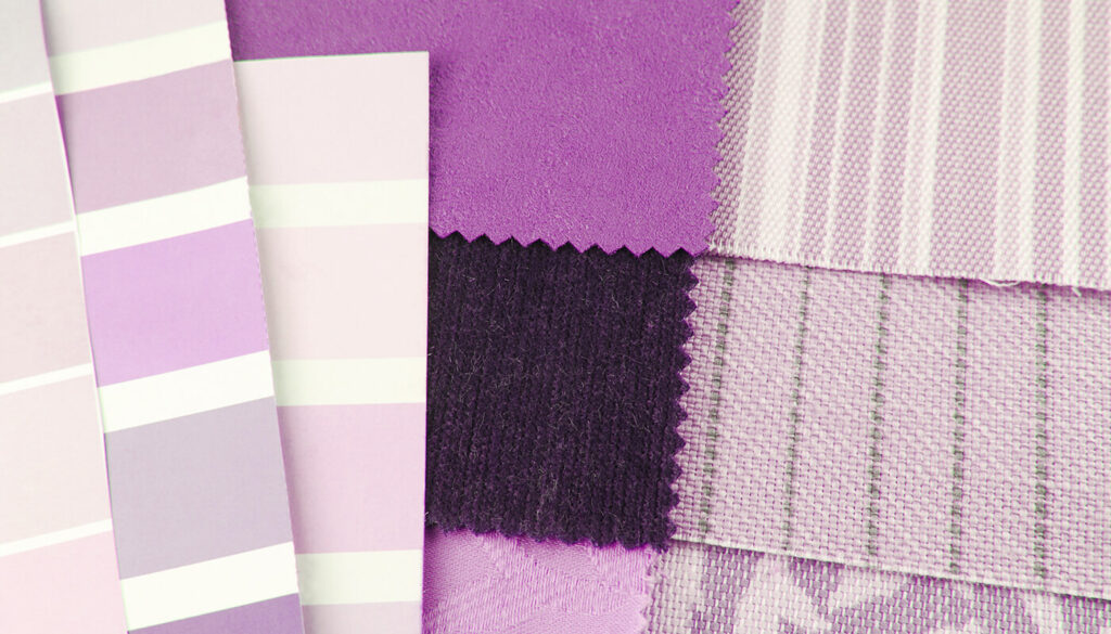 A monochromatic flat lay of paper and fabric swatches of different textures, all in varying shades of purple.
