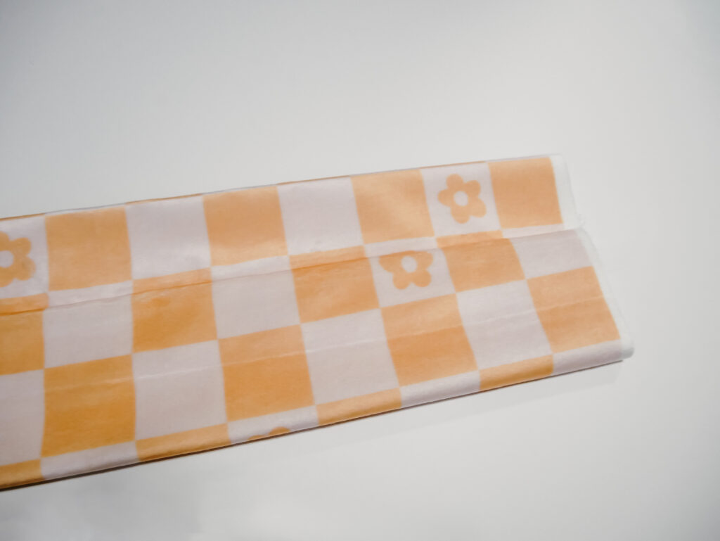 Tan and orange checkerboard fabric on white table 