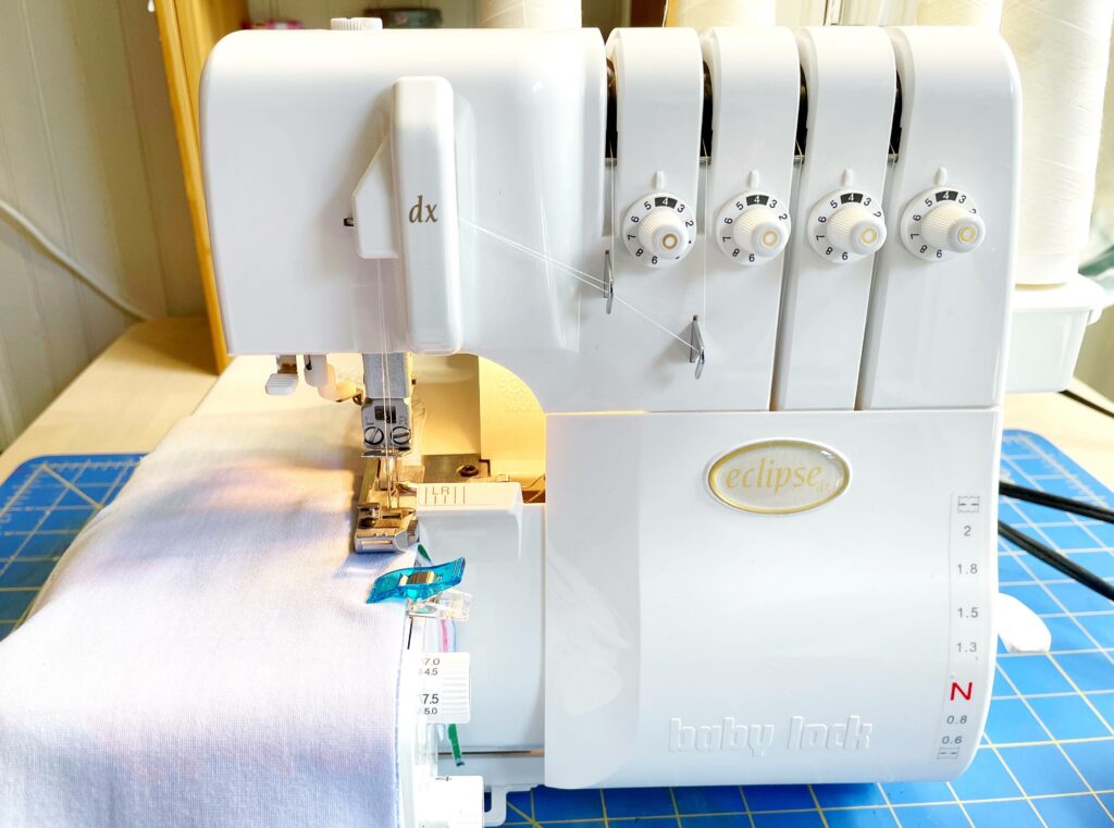 Fleece material to make a headband is being sewn together using a serger.