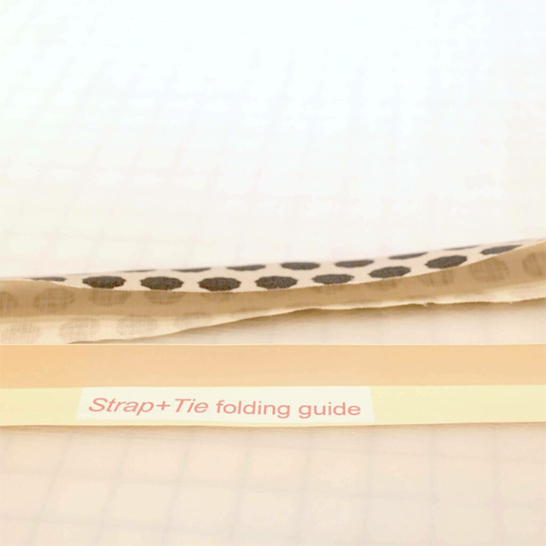 Shaping a long thin piece of fabric with folded strip of paper cut from a manila folder. The paper acts as a folding guide. 