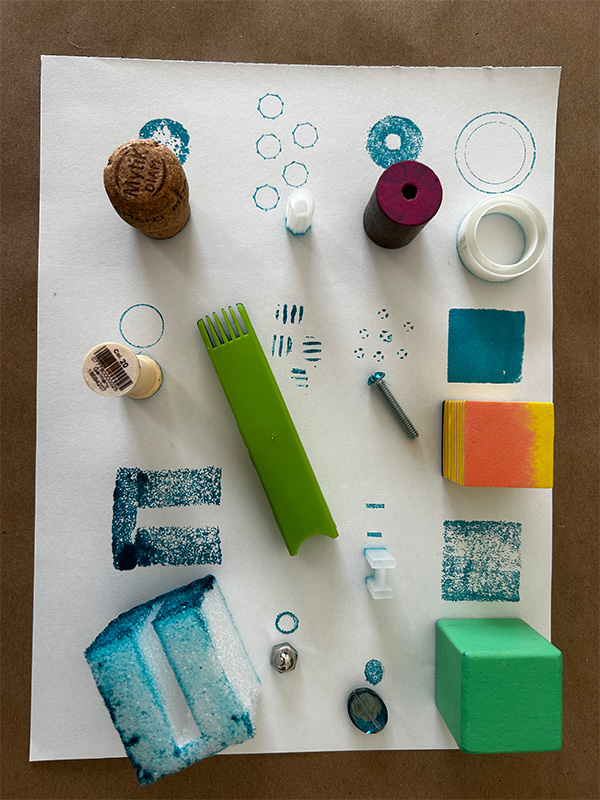 Found items lay on a white paper, near their prints in blue ink.