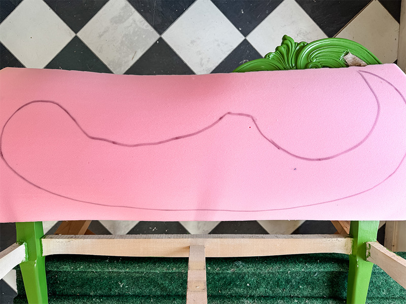 A piece of foam lays on the settee chair with a traced out shape to be cut and fitted to the chair.