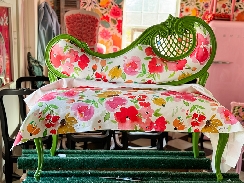 Floral fabric rests on the seat of a settee.
