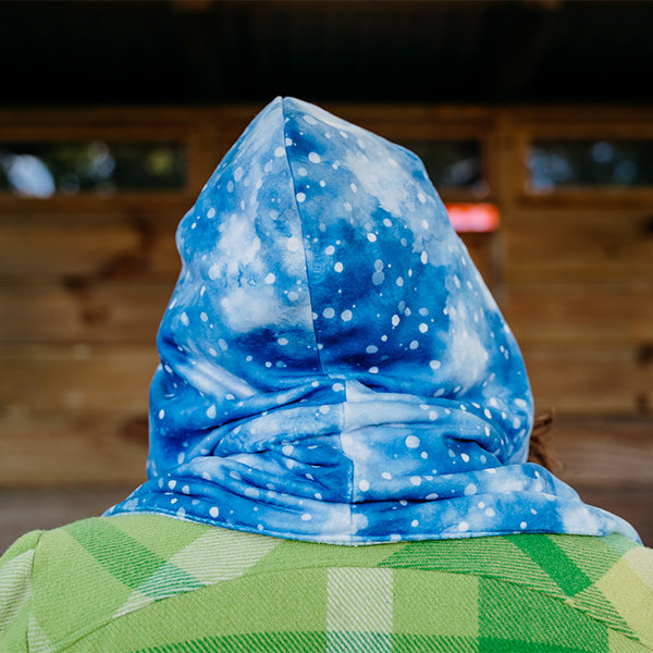 A back view of the hooded scarf. The fabric is blue with small white circles in different sizes, like snowflakes.