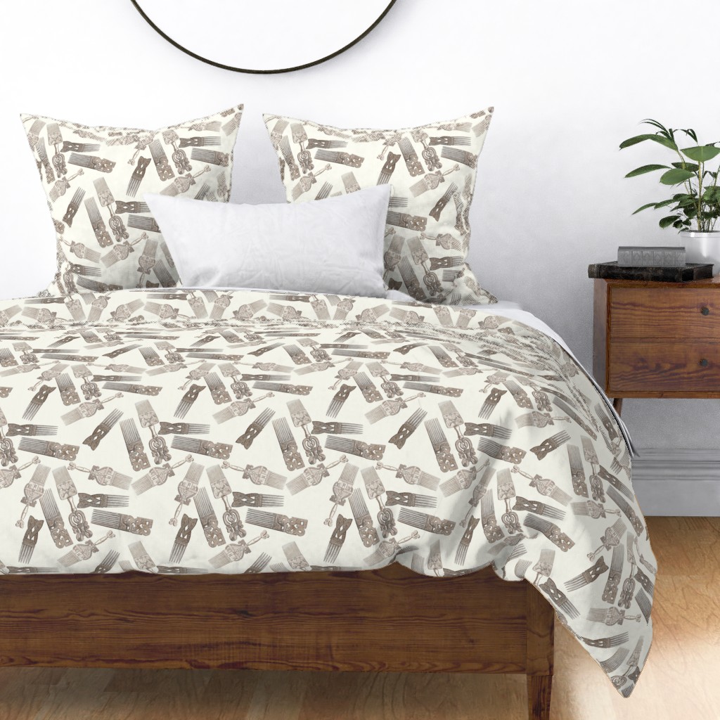 Brown afro picks float through a cream background on a duvet cover on a wooden bed. A green plant on a small wooden bedside table is to the right.