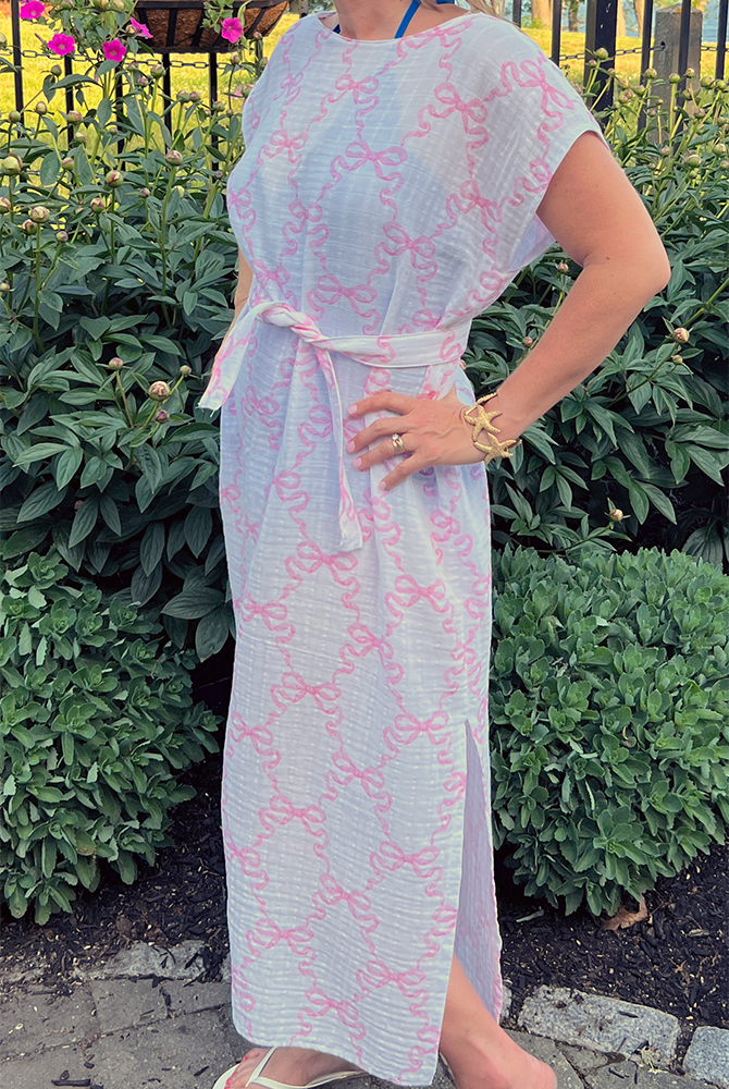 A look at the finished caftan belted. The fabric design features pink squiggles connecting with bows repeating on a white background.