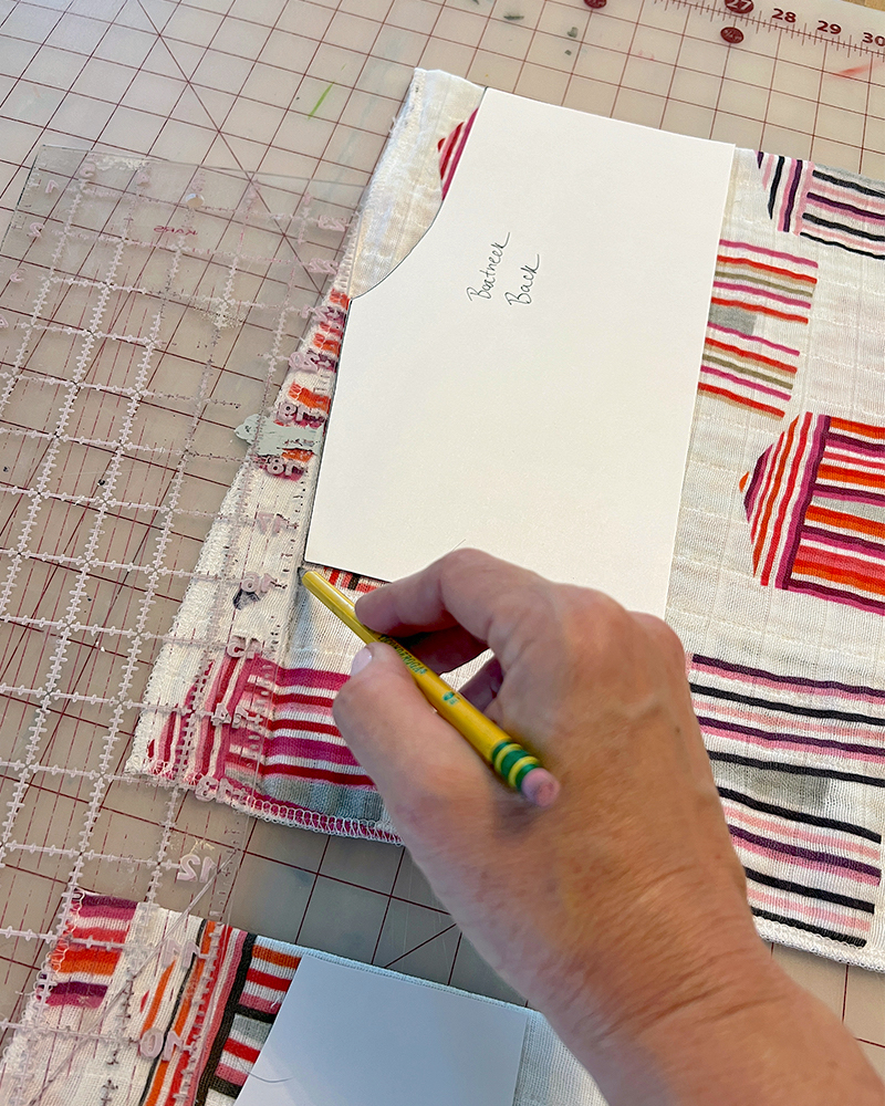 Creating the boatneck front. Drawing out the boatneck on a piece of fabric featuring hot pink cabanas.